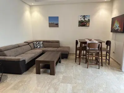 a living room with a couch and a table at TAJ NOUACEUR AéROPORT MOHAMMED V in Nouaceur