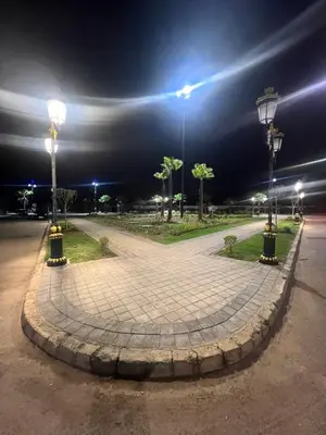 a park at night with two lights on a sidewalk at TAJ NOUACEUR AéROPORT MOHAMMED V in Nouaceur