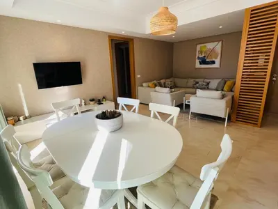 a living room with a white table and chairs at Duplex Rooftop d'exception terrasse panoramique de 100 m2 in Casablanca