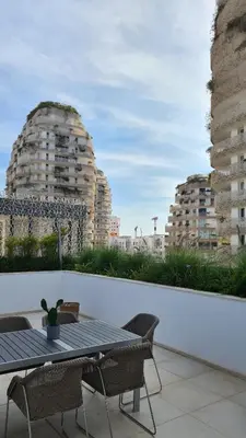 a table and chairs on a balcony with buildings at Duplex Rooftop d'exception terrasse panoramique de 100 m2 in Casablanca