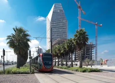 a red tram on a city street with palm trees at A 2 minutes de Casa Finance City, appartement avec 2 Chambres in Casablanca