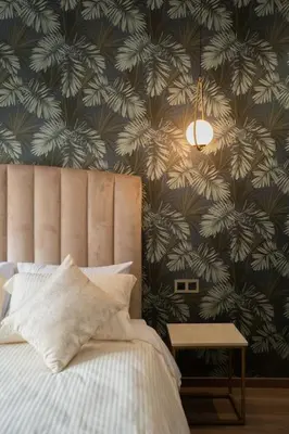 a bedroom with a bed and a wall covered in leaves at New upscale central maarif flat in Casablanca