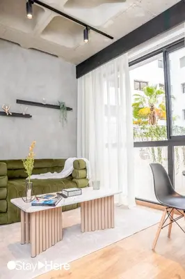 a living room with a green couch and a table at Stayhere Casablanca - Gauthier 1 - Modern Residence in Casablanca