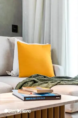 a pile of books on a coffee table in front of a couch at Stayhere Casablanca - Gauthier 1 - Modern Residence in Casablanca