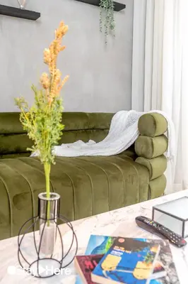 a living room with a green couch with a vase on a table at Stayhere Casablanca - Gauthier 1 - Modern Residence in Casablanca