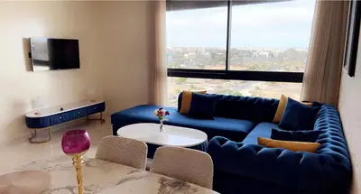 a living room with a blue couch and a table at Studio de luxe à casa finance city in Casablanca