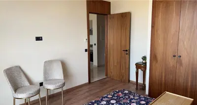 a living room with two chairs and a door at Studio de luxe à casa finance city in Casablanca