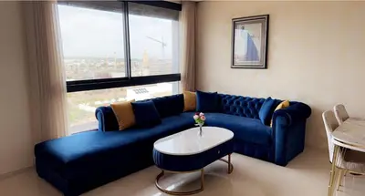 a blue couch in a living room with a window at Studio de luxe à casa finance city in Casablanca