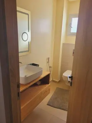a bathroom with a sink and a mirror and a toilet at Luxury in the heart of Hay Riad in Rabat
