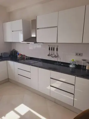 a kitchen with white cabinets and black counter tops at Luxury in the heart of Hay Riad in Rabat