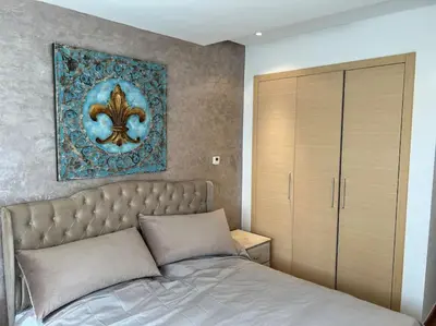 a bedroom with a bed and a painting on the wall at Superbe appartement avec piscine in Rabat