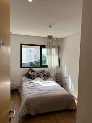 a bedroom with a large bed with a window at Superbe appartement avec piscine in Rabat