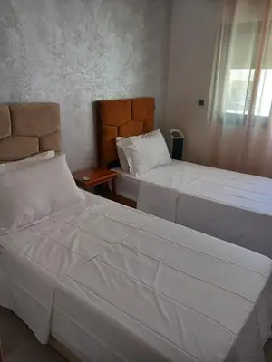 a bedroom with two beds and a window at Superbe Appartement Bouskoura in Bouskoura