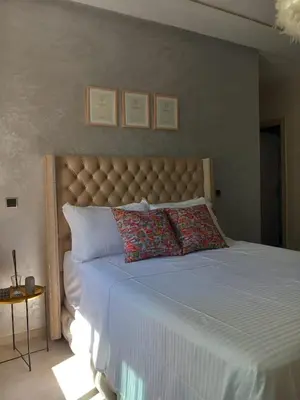 a bedroom with a large bed with a white bedspread at Superbe Appartement Bouskoura in Bouskoura