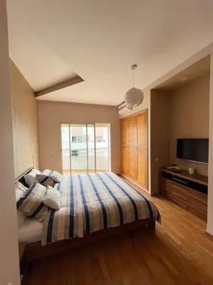 a large bedroom with a bed with a striped blanket at Big luxury apartment near airport in Nouaceur