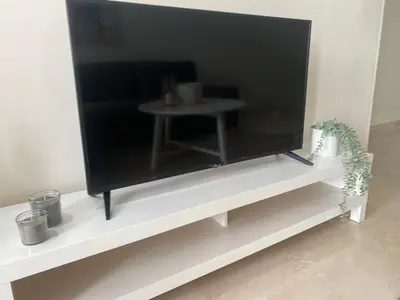a large flat screen tv sitting on a white shelf at Luxueux appartement avec vue panoramique WELCOME STAY in Mohammedia