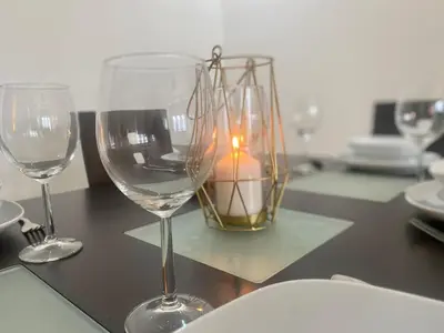 two wine glasses and a candle on a table at Luxueux appartement avec vue panoramique WELCOME STAY in Mohammedia