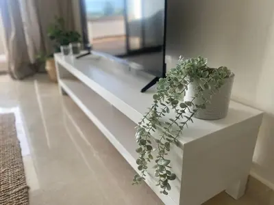 a white dresser with a potted plant on it at Luxueux appartement avec vue panoramique WELCOME STAY in Mohammedia
