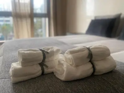 a pile of folded towels on a bed at Luxueux appartement avec vue panoramique WELCOME STAY in Mohammedia