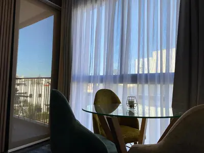 a glass table and chairs in a room with a window at Appartement Cosy et chaleureux - Casablanca centre in Casablanca