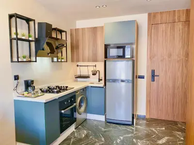 a kitchen with a refrigerator and a stove at Appartement Cosy et chaleureux - Casablanca centre in Casablanca