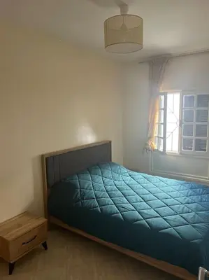 a bedroom with a blue bed and a window at Au centre de Agdal in Rabat