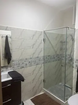 a bathroom with a glass shower and a sink at Au centre de Agdal in Rabat
