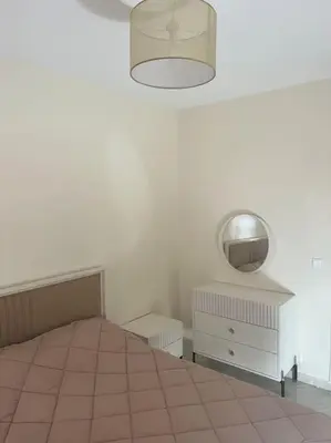 a white room with a bed and a mirror at Au centre de Agdal in Rabat