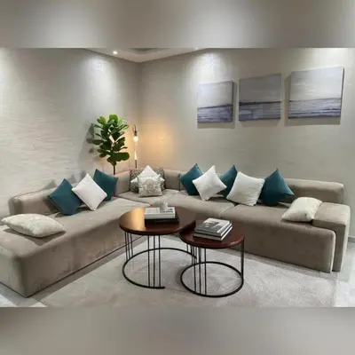 a living room with a couch with blue and white pillows at Miramare Cosy appartement pied dans l'eau avec piscine in Mohammedia