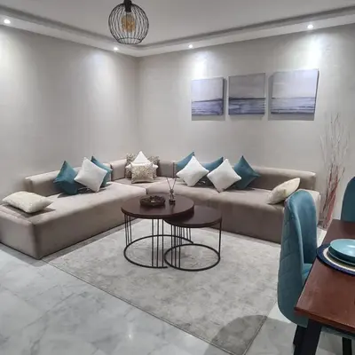 a living room with a couch and a table at Miramare Cosy appartement pied dans l'eau avec piscine in Mohammedia