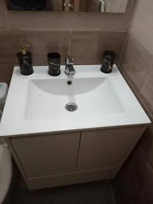 a bathroom sink with two black cups on it at 3 Bedroom Apartment with Wifi in Casablanca