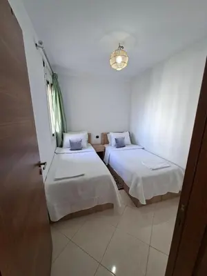 a small room with two beds and a window at Appartement Fasthôtel Casablanca in Casablanca