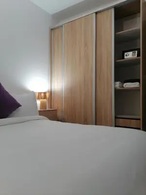 a bedroom with a bed and a wooden cabinet at Appartement Fasthôtel Casablanca in Casablanca