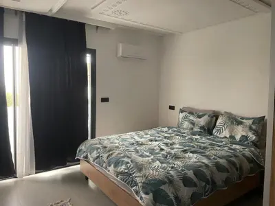 a bedroom with a bed and a window at Appt 1 ch salon for saison in Rabat