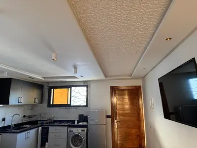 a kitchen with a ceiling with a washer and dryer at Appt 1 ch salon for saison in Rabat