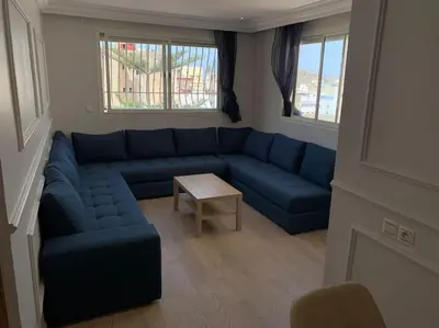 a living room with a blue couch and a table at Chic & Cozy Studio Centre Ville Super Propre in Casablanca