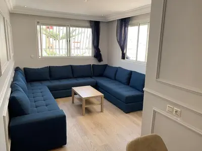 a living room with a blue couch and a table at Chic & Cozy Studio Centre Ville Super Propre in Casablanca