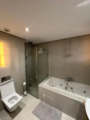 a bathroom with a tub and a toilet and a shower at Marina Casa Del Mar - Amazing Sea & Mosque views in Casablanca