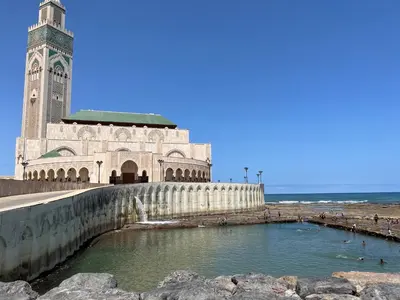 a building with a clock tower next to the ocean at appartement en plein centre de casablanca in Casablanca