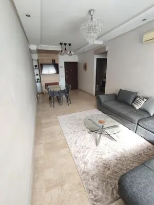 a living room with a couch and a table at Chaleureux Appartement à 1 min à pied de la Mosquée Hassan II in Casablanca