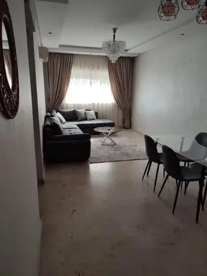 a living room with a couch and a table at Chaleureux Appartement à 1 min à pied de la Mosquée Hassan II in Casablanca