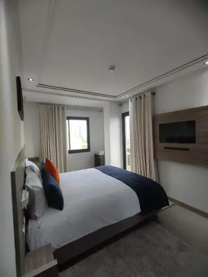 a bedroom with a bed and a flat screen tv at LOTUS HOTEL Casanearshore in Casablanca