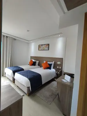 a bedroom with two beds with orange pillows at LOTUS HOTEL Casanearshore in Casablanca