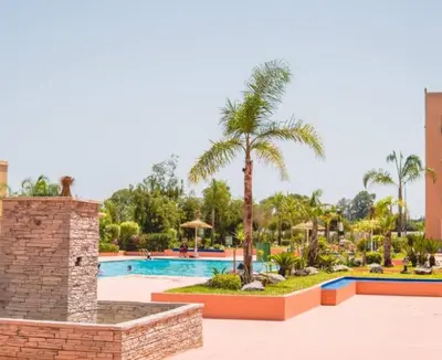 a resort with a swimming pool and palm trees at Ricoflores PALM in O Ben Slimane