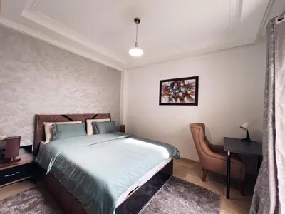 a bedroom with a bed and a desk and a table at High Standing & cozy apartment in central Casablanca in Casablanca