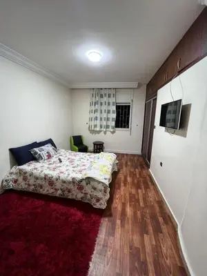 a bedroom with a bed and a red rug at Résidence Faouazi in Casablanca