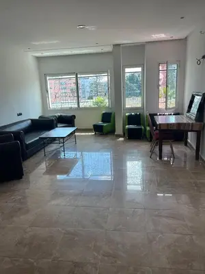a room with a couch and a table and chairs at Résidence Faouazi in Casablanca