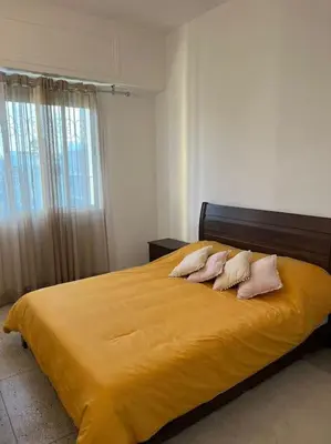 a bedroom with a yellow bed with three pillows at Cozy place in the heart of rabat in Rabat