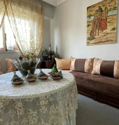 a living room with a table and a couch at Appartement calme et confort entier à 10 mn de la corniche, une demie heur de stade d honneur in Casablanca