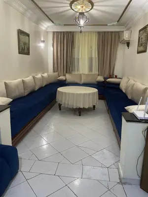 a living room with a blue couch and a table at Bel appartement quartier Bourgogne in Casablanca